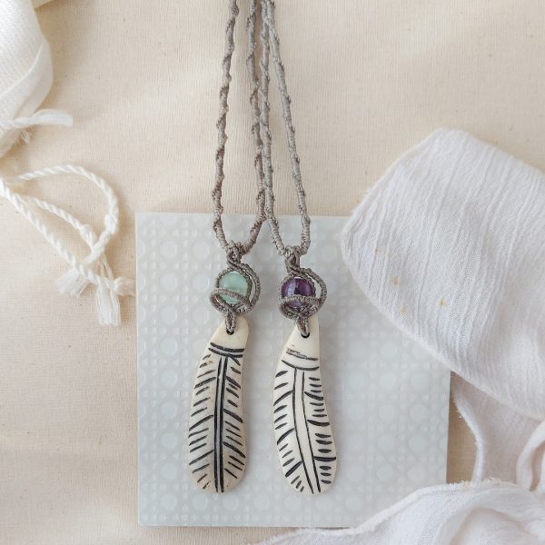 amethyst gemstone pendant with macrame details and a feather charm