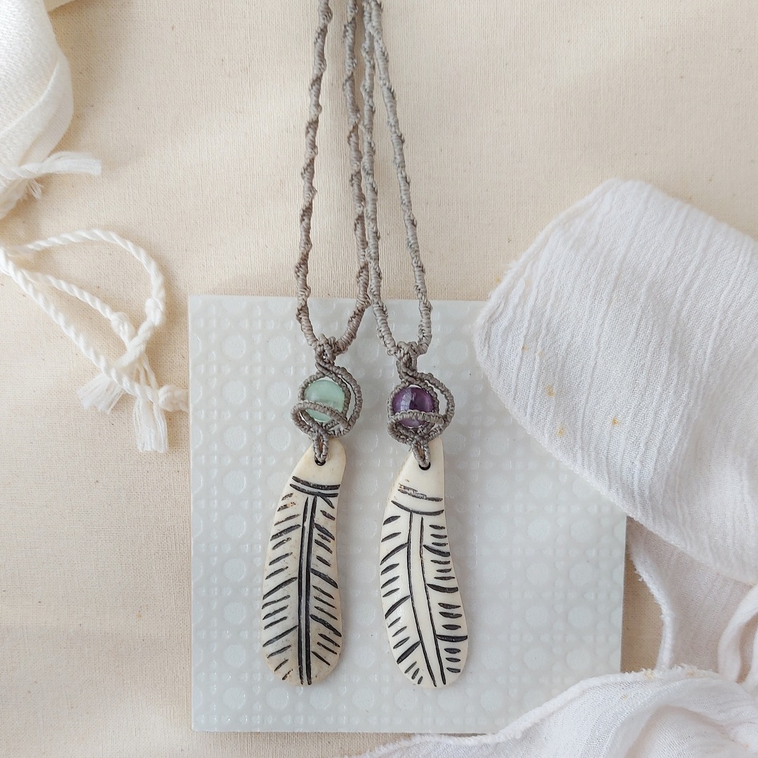 amethyst gemstone pendant with macrame details and a feather charm